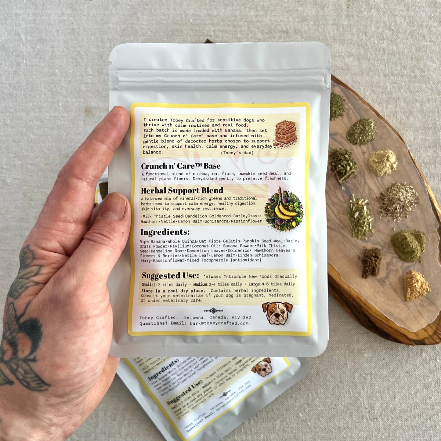 Hand holding a package of Crunch n Care with ingredients and usage information on a neutral background.