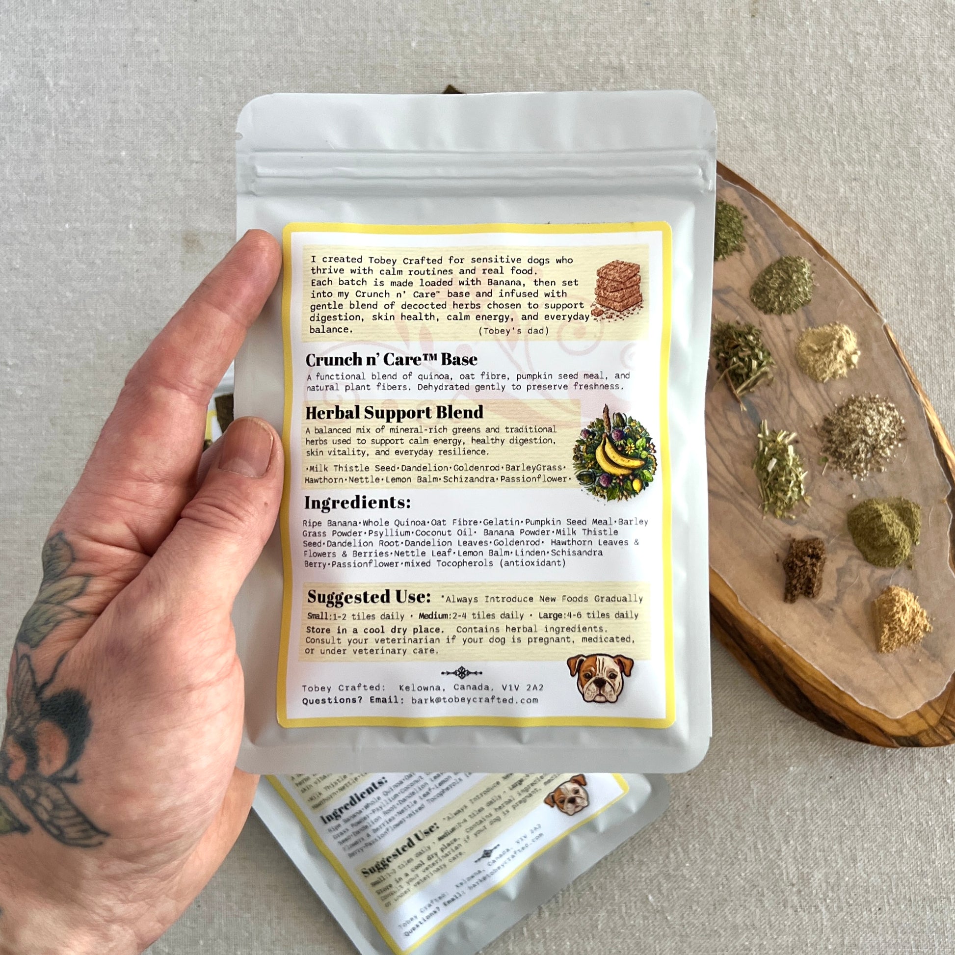 Hand holding a package of Crunch n Care with ingredients and usage information on a neutral background.