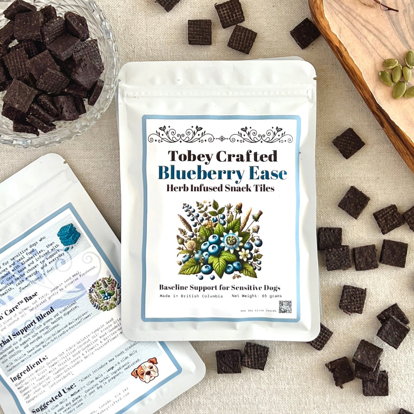 Tobey Crafted Blueberry Ease snack tiles packaging with ingredients on a textured surface.