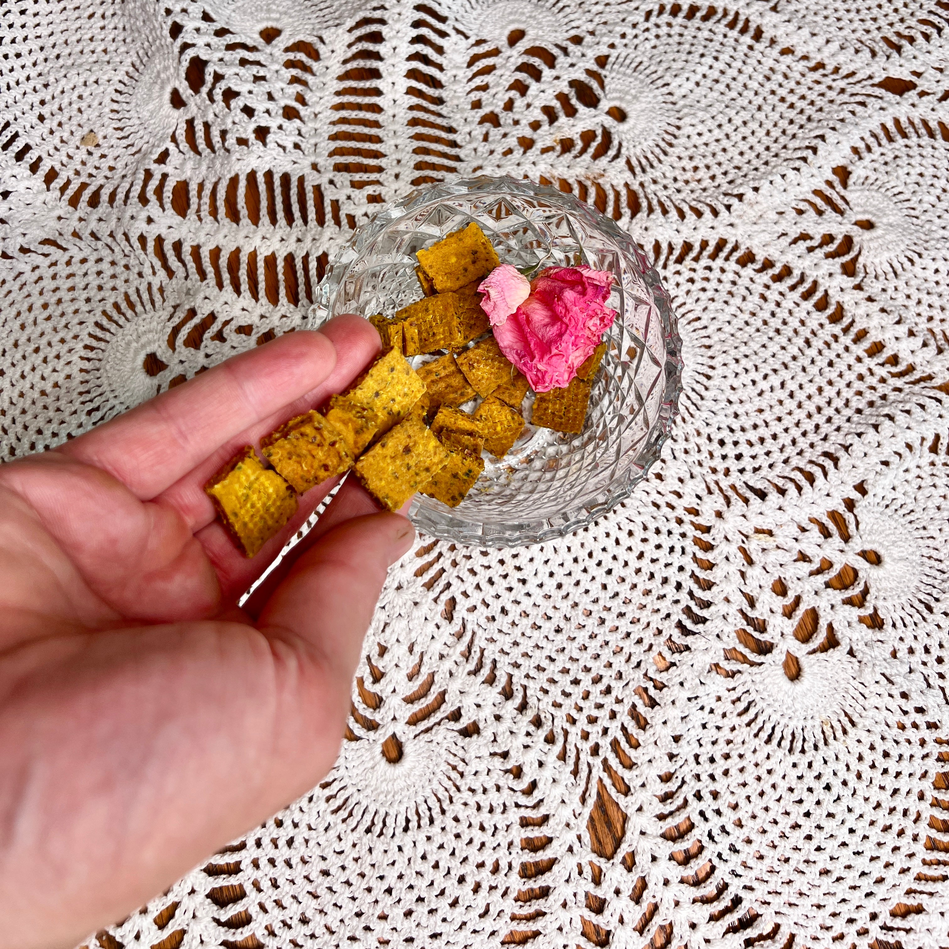 A crystalBowlIn on a crochet doily and contains square dog treats 