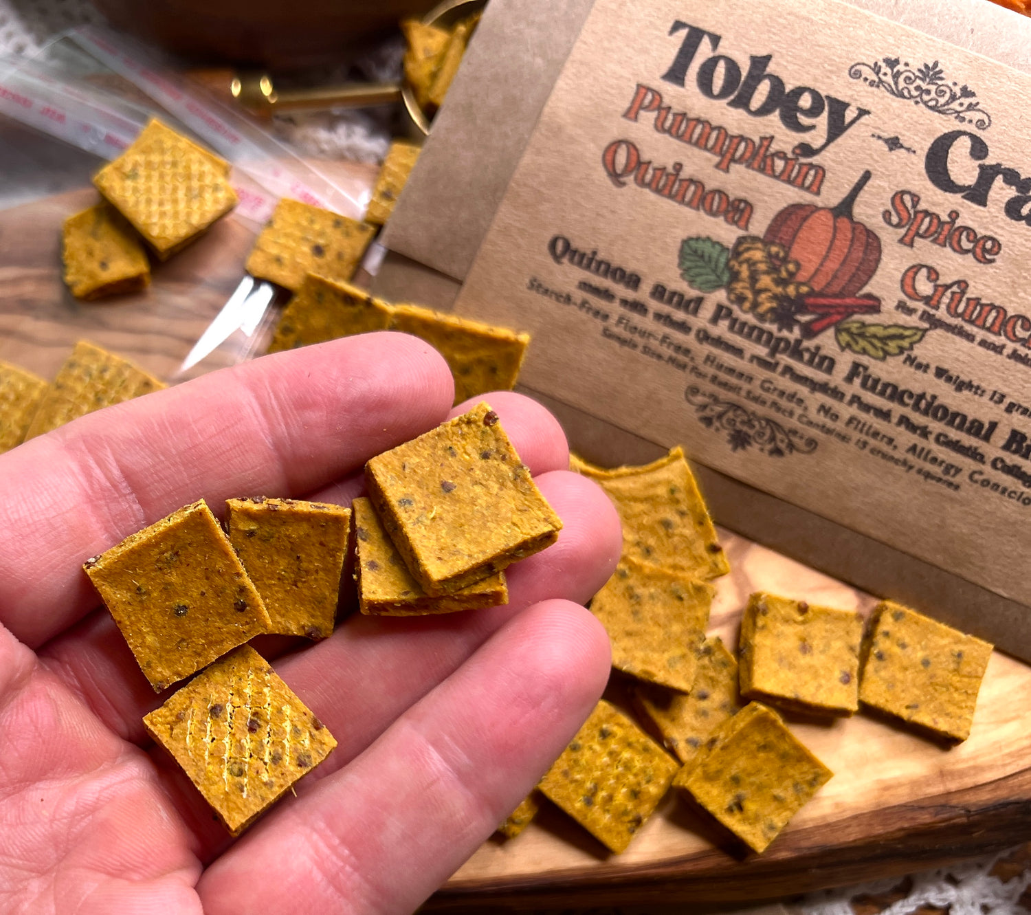 Hands holding quinoa crunchies with the intro packs pictured in the background 