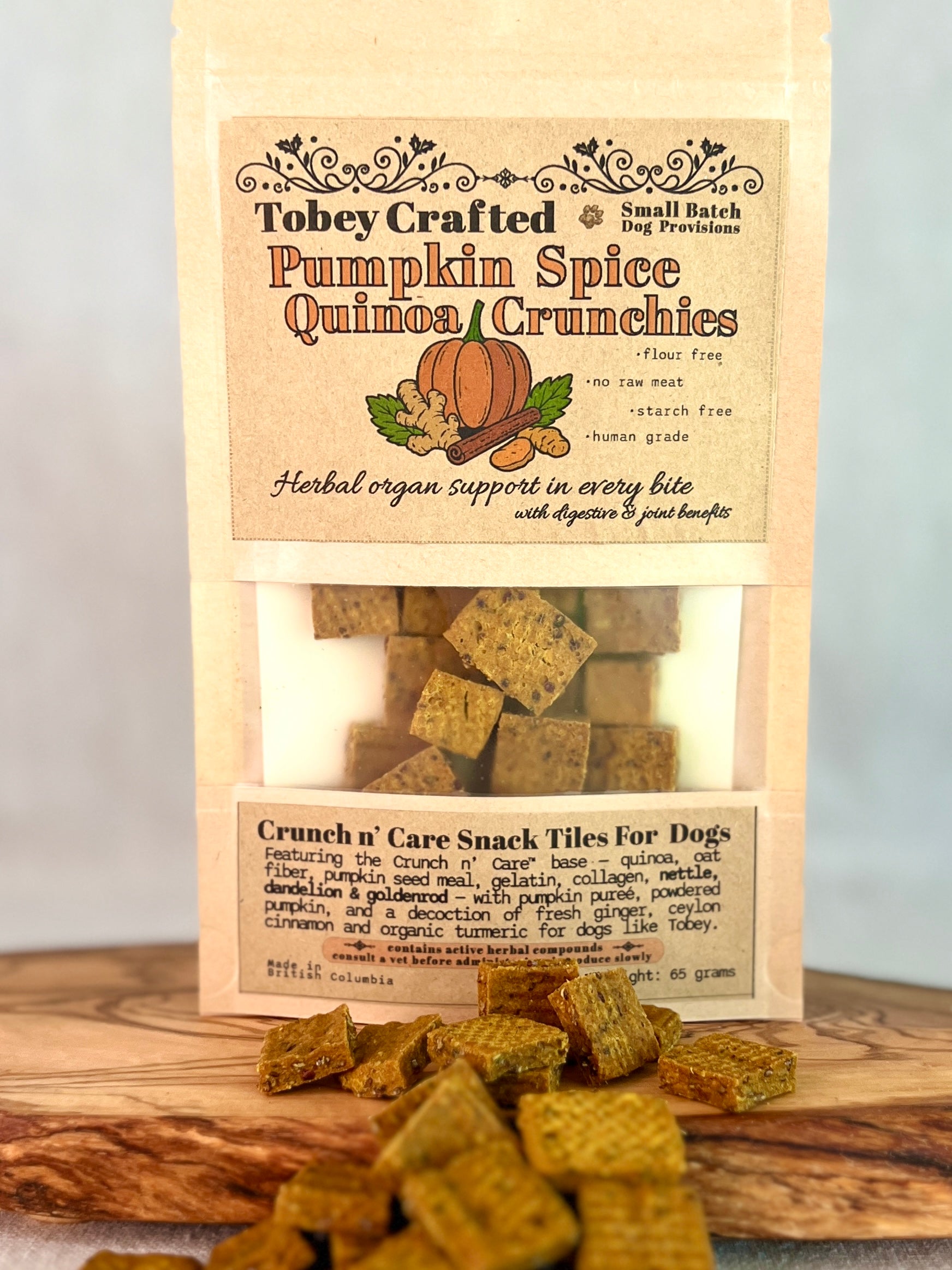 Tobey Crafted Pumpkin Spice Quinoa Crunchies dog treats packaging on a wooden surface.